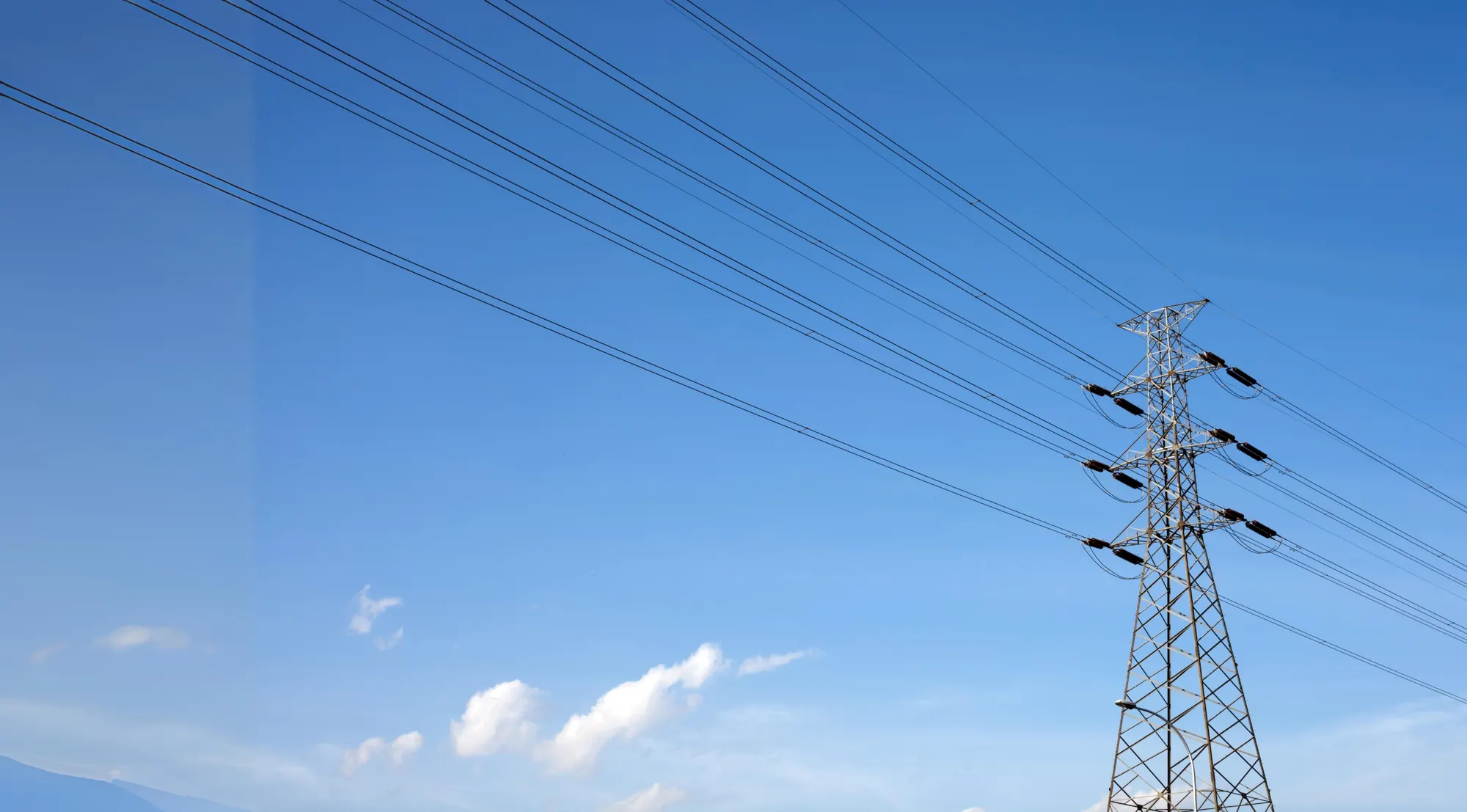 Strommast vor blauem Himmel