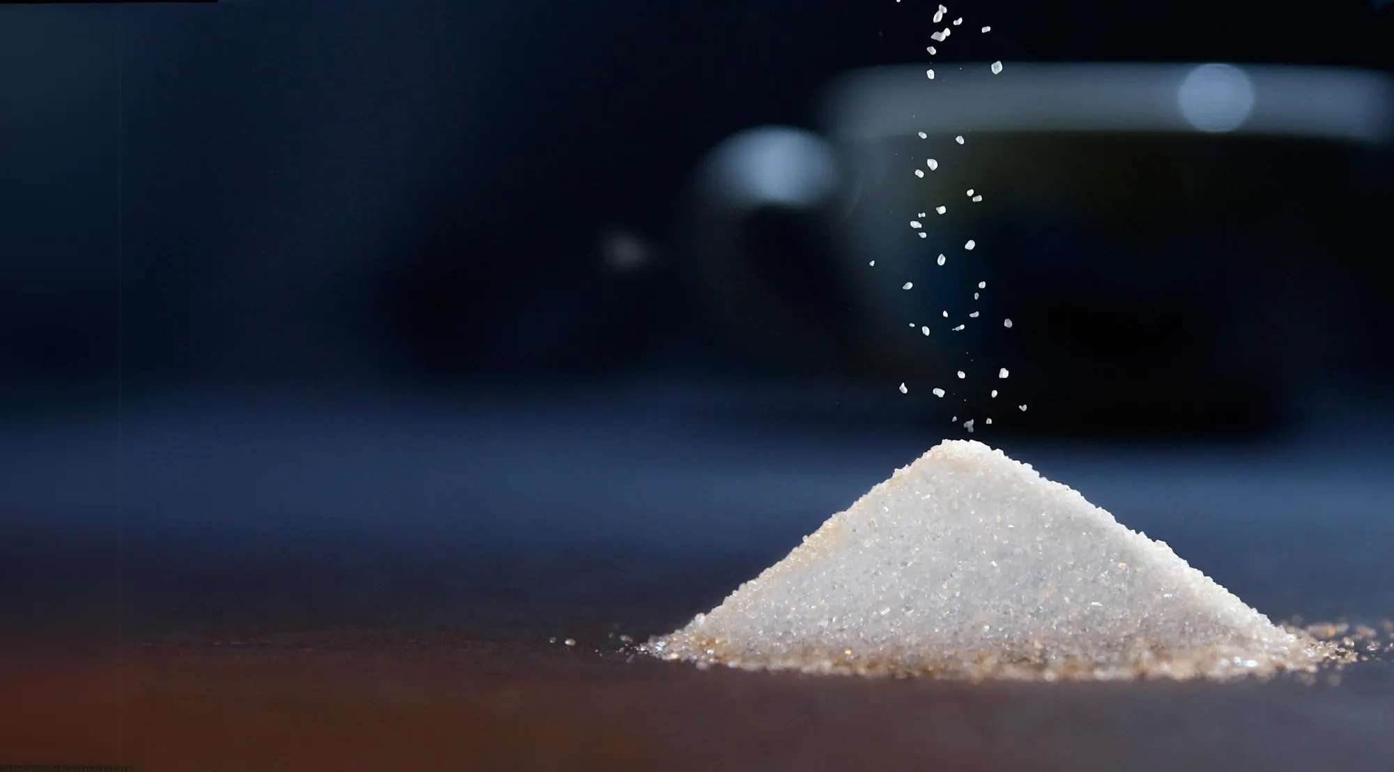Zucker rieselt auf einen kleinen Haufen